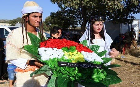  Yezidi man and woman from the cultural center of Lalish, located in Duhok, lay a wreath colored with the flag of Kurdistan at the Barzani Anfal memorial in Barzan, Duhok. File photo: Rudaw