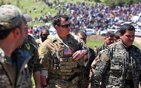 This AFP photo shows US servicemen from the US-led coalition visiting fighters with the Kurdish People’s Protection Units (YPG) at the site of Turkish airstrikes near northeastern Syrian Kurdish town of Derik in April.