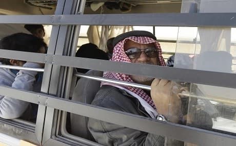 An ISIS member looks out of the window of a bus in the Qara area of Syria's Qalamoun region on Monday. Photo: Louai Beshara | AFP