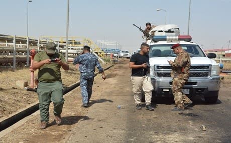 Iraqi security forces and members of the Saraya al-Salam, a group formed by Iraqi Shiite Muslim cleric Moqtada al-Sadr, inspect the site of suicide bombings at a power plant in Samarra, north of Baghdad on September 2. Photo: AFP /Mahmud Saleh