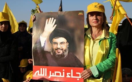 A supporter of the Lebanese Shiite movement Hezbollah holds a poster bearing a portrait of Hassan Nasrallah as she attends on August 31, 2017 a rally in Baalbek to celebrate the return of its fighters after fighting a week-long offensive against the ISIS group on Syria's side of the Lebanese border. Photo: AFP