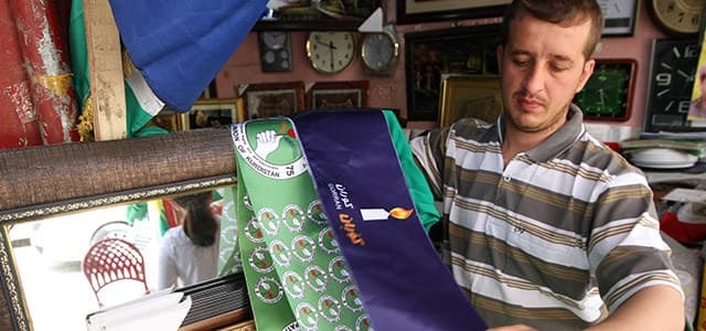 File photo shows a Kurdish man hols the flags of the Patriotic Union of Kurdistan (PUK) and Gorran Movement in Sulaimani in 2014. Photo: Rudaw/Sartip Othman 