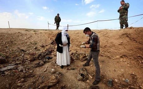 Yezidis look for evidence of their loved ones in a mass grave in 2015. Photo: Safin Hamed/AFP