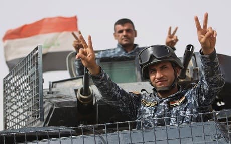 Iraqi forces members flash the sign for victory as they advance on September 23, 2017 to recapture the insurgent stronghold of Hawija after retaking the nearby northern town of Sharqat from the ISIS group on the second day of a new offensive. Photo: AFP/ Ahmad al-Rubaye