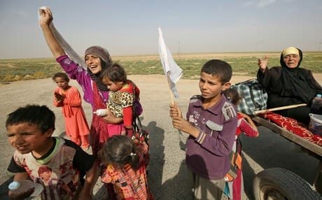 Members of an Iraqi family, displaced from the outskirts of Islamic State group stronghold Hawija, raise white flags while travelling on the road outside the town on October 3, 2017. AFP / AHMAD AL-RUBAYE