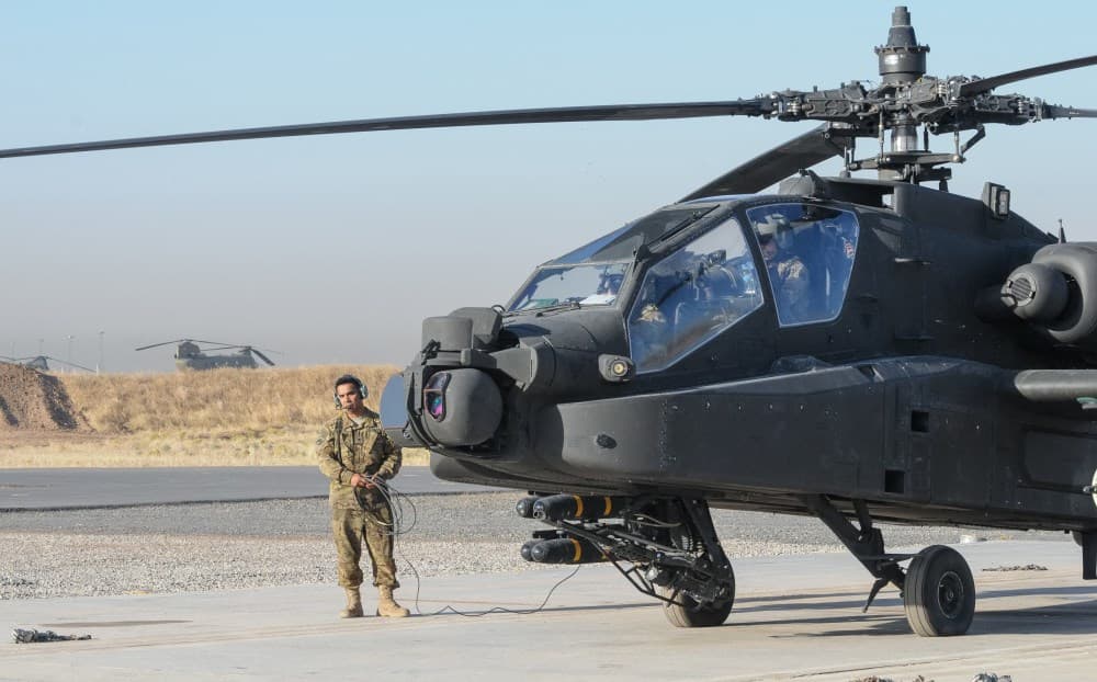 Coalition soldiers conduct pre-flight inspections of an Apache helicopter in Erbil in July. Photo: Capt. Stephen James/US Army
