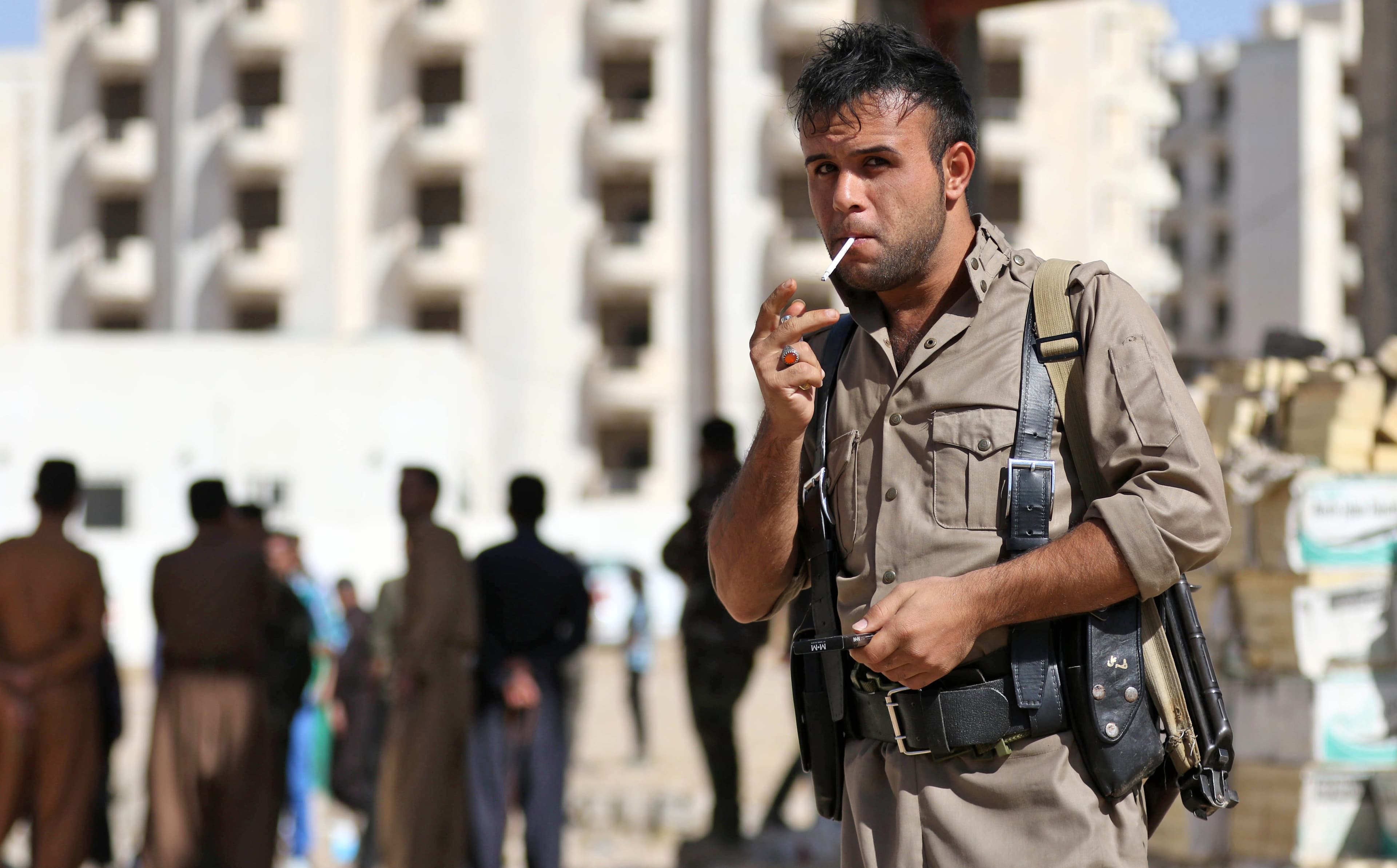 A member of Kurdish security forces stands guard at an unfinished housing complex in Erbil where persons displaced from Kirkuk are taking shelter on Thursday. Photo: Safin Hamed/AFP