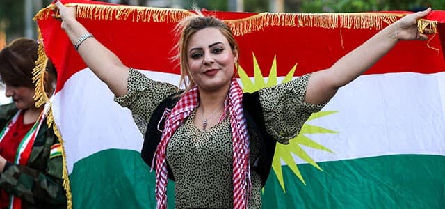 An Iraqi Kurdish woman poses with the flag of of the Kurdistan region during a demonstration outside the UN Office in Erbil on October 21, 2017, protesting against the escalating crisis with Baghdad. Photo: AFP / Safin Hamed