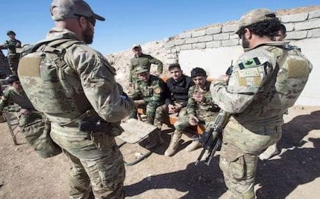 Canadian special forces soldiers, left and right, speak with Kurdish Peshmerga soldiers at an observation post in the Kurdistan Region. The Canadian Press file photo/Ryan Remiorz 