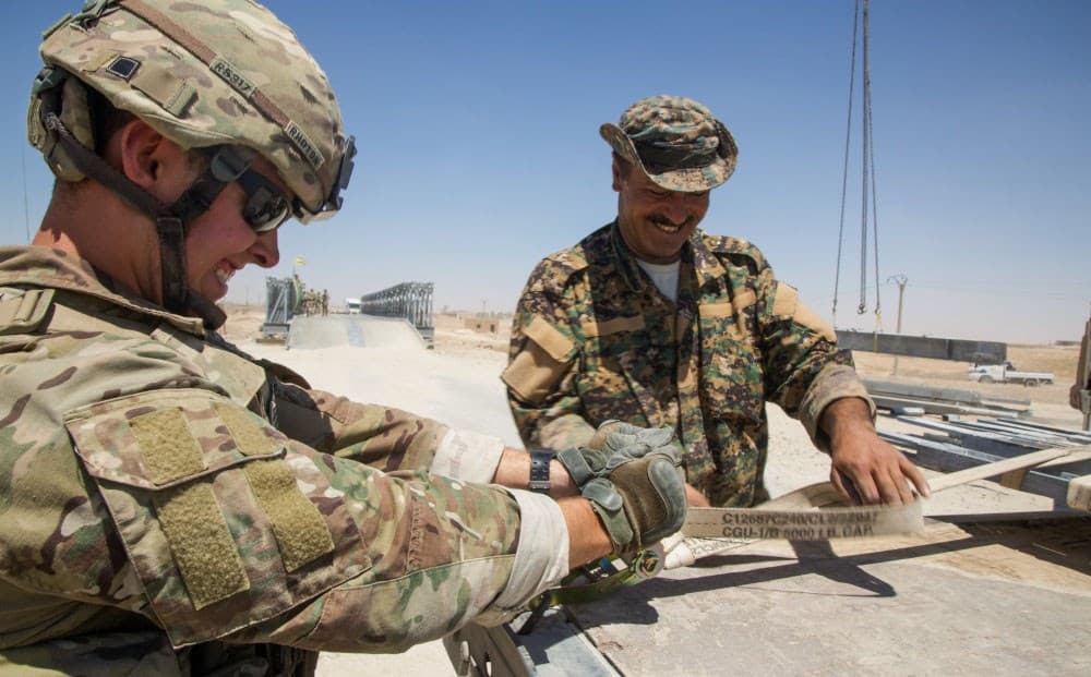 A US army engineer works with a member of the SDF to help maintain a bridge near Raqqa in July. Photo: Sgt. Mitchell Ryan/US Army