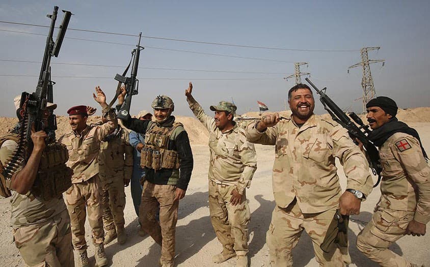 Iraqi forces celebrate after taking the western Anbar border town of al-Qaim earlier this month. Photo: Ahmad al-Rubaye/AFP