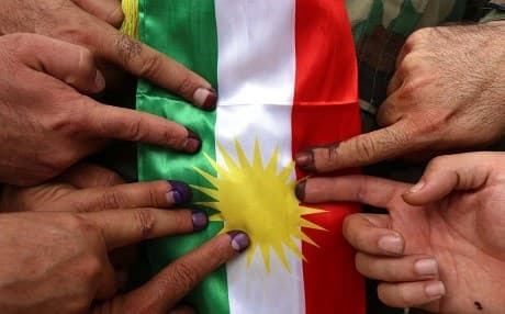 Members of a Kurdish Peshmerga battalion showing their ink-stained fingers in front of a Kurdish flag after voting in the Kurdish independence referendum in Erbil. File photo: AFP / Safin Hamed