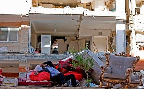 An Iranian man rests as he lies atop salvaged mattresses and items outside damaged buildings in the Kurdish town of Sarpol-e Zahab in the western Kermanshah province near the border with the Kurdistan Region on November 14, 2017 following a 7.3-magnitude earthquake that left hundreds killed and thousands homeless two days before. File photo: AFP/Atta Kenare