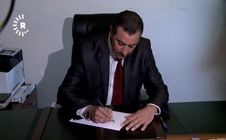 Haval Abubakir writes the official letter that confirms him as the new Governor of Sulaimani on December 4, 2017. Photo: Rudaw TV