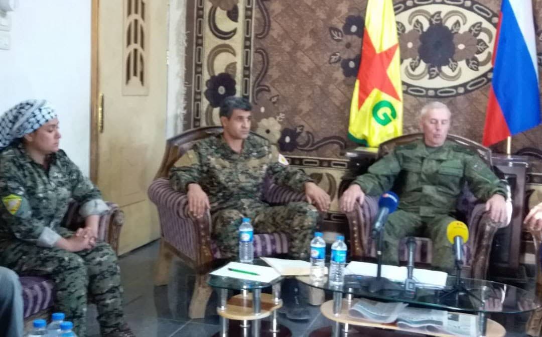 YPG and Russian flags on display during a joint press conference in Deir ez-Zor on Sunday. Photo: YPG