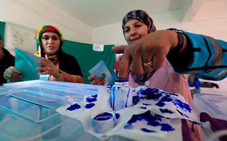 A woman dips her woman in ink after voting in local council elections in Qamishli on December 1. Photo: Delil Souleiman/AFP