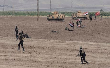 Turkish and Iraqi soldiers walk with Turkish tanks during a military drill in Silopi, near the Habur border gate with Iraq, southeastern Turkey,  on Sept. 26, 2017, a day after the Kurdistan Region held a referendum on independence, a move which was strongly opposed to by Turkey and Iraq. AP photo