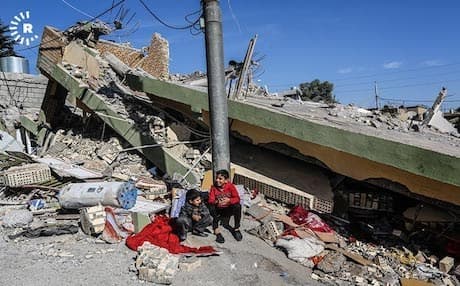 Two children sit next to the remains of a house in the town of Darbandikhan after it suffered some of the most serious damage in the Kurdistan Region. Photo: Sartip Othman | Rudaw