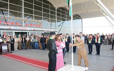 Chief of Erbil International Airport, Talar Faeq, raises the flag of Kurdistan at the airport on Kurdistan Flag Day, December 17. Photo: EIA