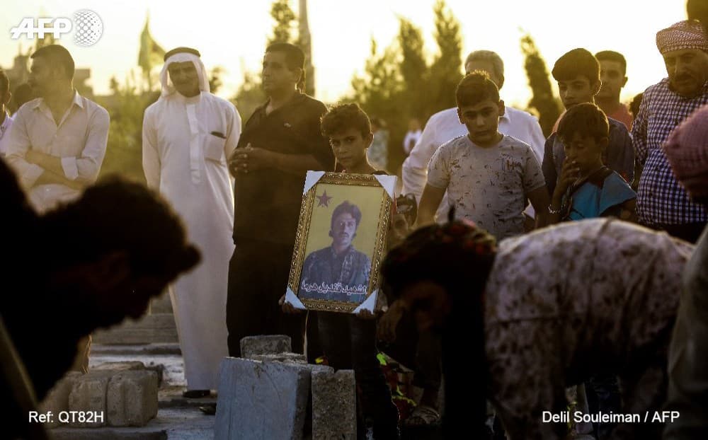 Mourners grieve at a funeral for a YPG fighter killed in Raqqa in August. Photo: Delil Souleiman/AFP
