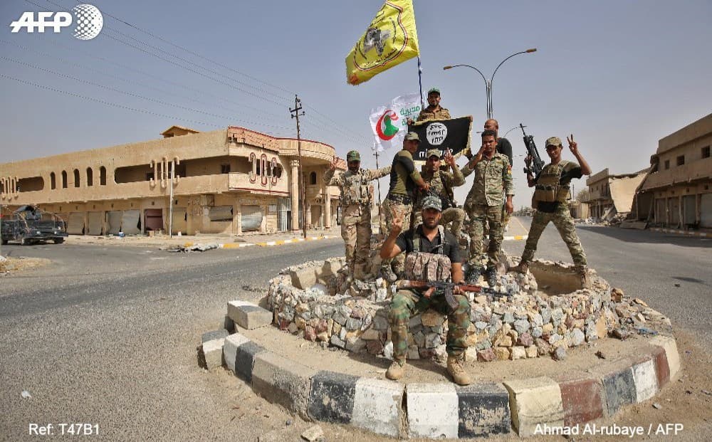 Iraqi forces pose in Hawija town in Kirkuk, retaken from ISIS in early October 2017. Photo: Ahmad al-Rubaye/AFP