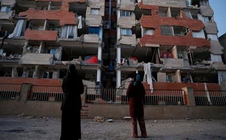 People look up at a damaged residential building following a 7.3-magnitude earthquake at Sarpole Zahab in Iran's Kermanshah province on November 13. Photo: AFP
