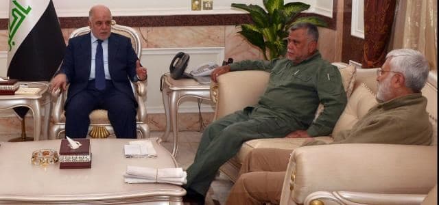 File photo shows Iraqi Prime Minister Haider al-Abadi [L] as he hosts Hadi al-Amiri [M] and Mahdi al-Muhandis from the Iran-backed Hashd al-Shaabi in Baghdad in October 2015. Photo: PM Media Office