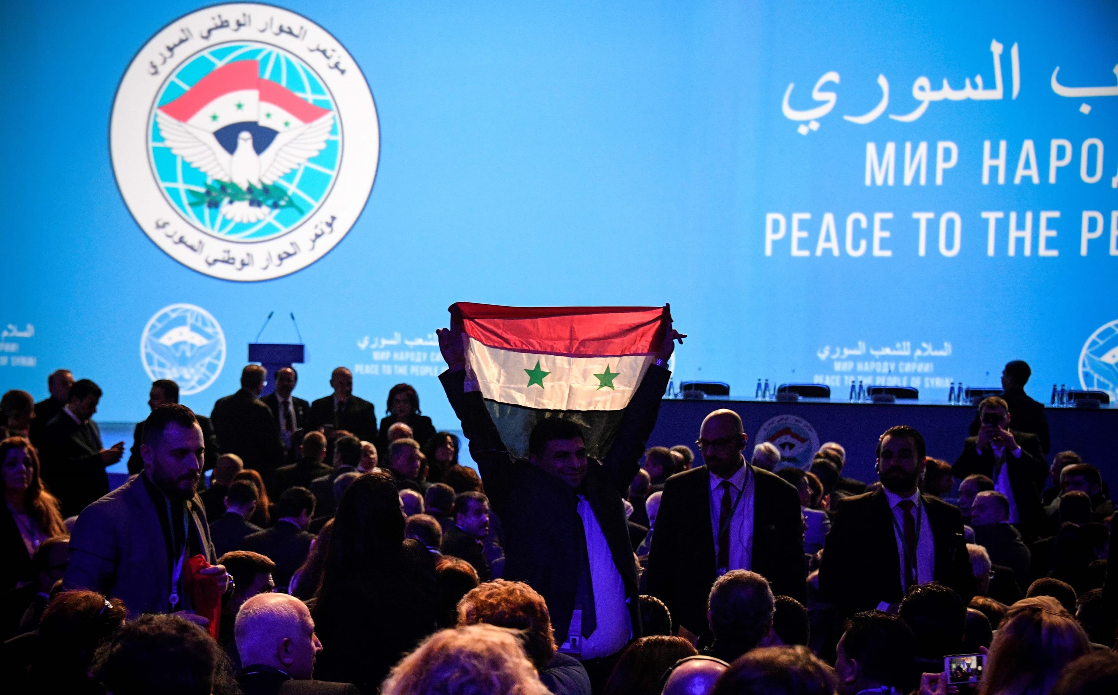 A man holds up a Syrian flag at the Syrian National Dialogue Congress in Sochi on Tuesday. Photo: Alexander Nemenov/AFP