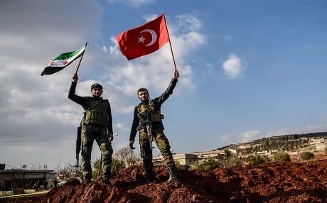 Fighters raise the flags of the Syrian opposition and Turkey in the town of Azaz in Afrin, Syria, on January 31, 2018. Photo: Ozan Kose | AFP