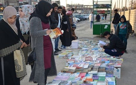Iraqis buy and sell books on a pavement in the former embattled city of Mosul on January 12, 2018 six months after Iraqi forces retook the northern city from Islamic State (IS) jihadists. Photo: AFP/ Ahmad Muwafaq
