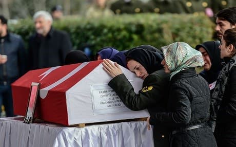 The wife (R) of a Turkish soldier killed in cross-border clashes with Kurdish People's Protection Units (YPG) forces in Afrin, reacts over his Turkish flag-draped coffin during a funeral ceremony in Istanbul on January 28, 2018. Photo:AFP/Yasin Akgul