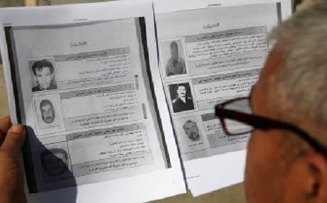 An Iraqi man looks at a list of names published for the first time by the Iraqi security services of the country's sixty most wanted people including members from ISIS, Al-Qaeda and the former Baath party on February 4, 2018 in Baghdad. Photo: AFP/Sabah Araar 