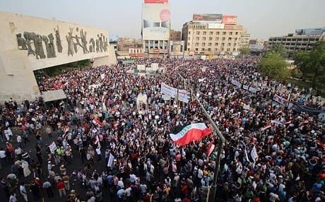 Iraqis demonstrators gathered in Tahrir Square wave their national flag and chant against corruption and poor services in Baghdad. Photo: AFP file photo