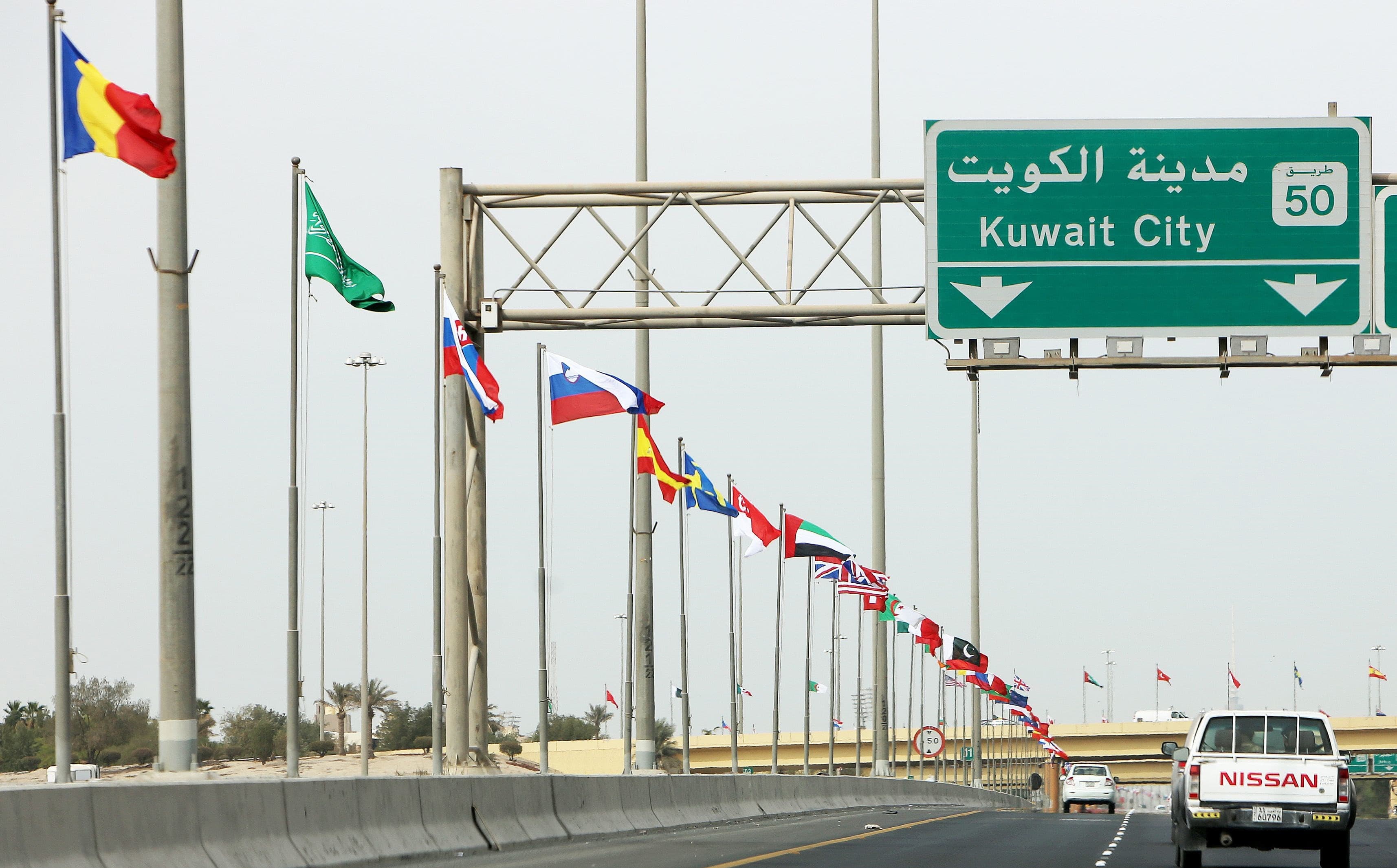 Flags of 70 countries participating in the Kuwait Conference for Reconstruction of Iraq fly along a highway in Kuwait City. Photo: Yasser al-Zayyat/AFP