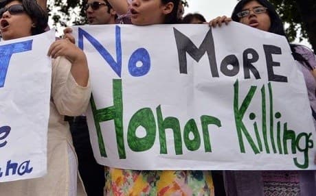 Women hold signs opposing honor killings in the Middle East. File photo: AFP