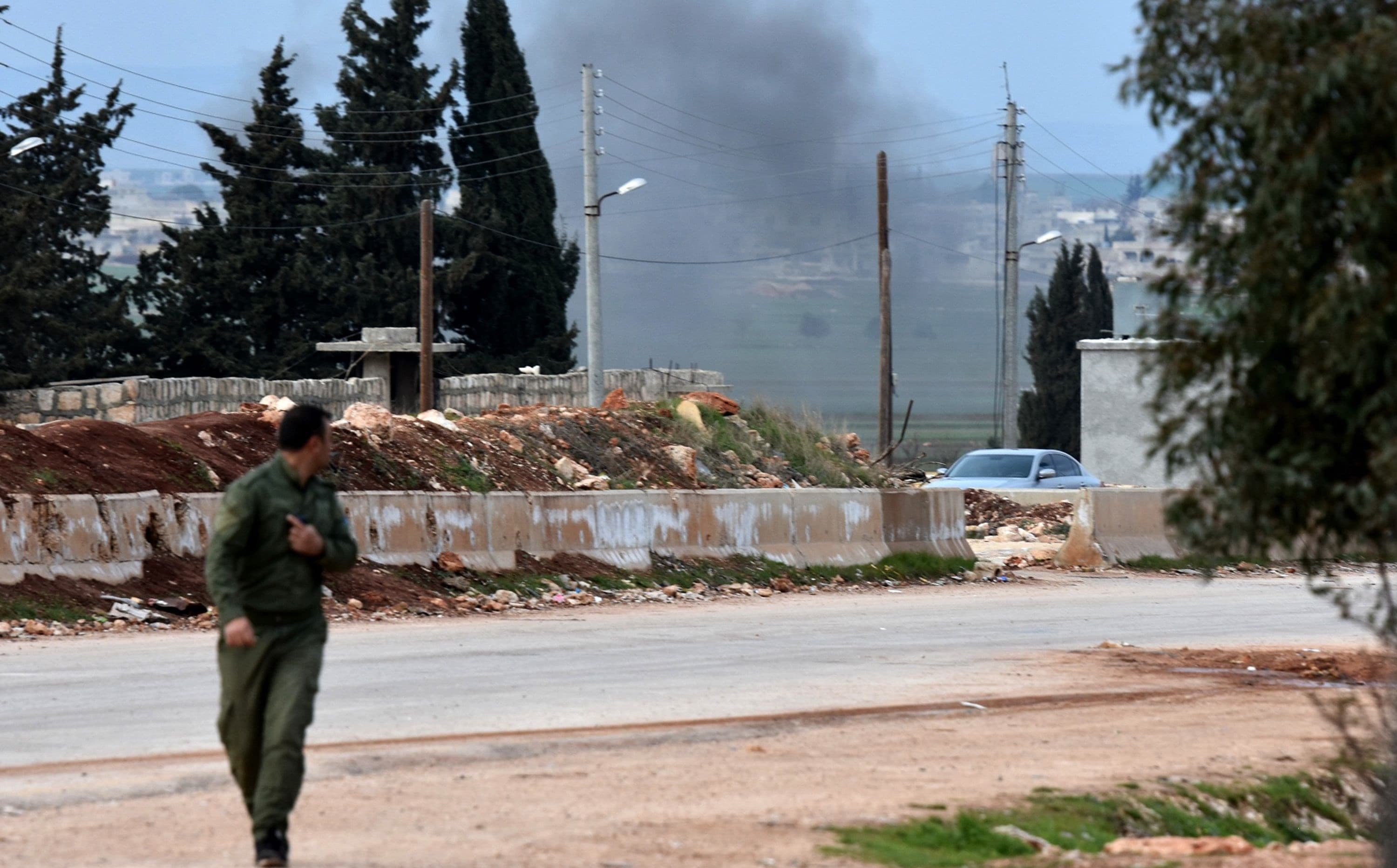 A Kurdish fighter looks at smoke rising from a Turkish artillery bombardment in Afrin after pro-Syrian government forces entered the region on Tuesday. Photo: George Ourfalian/AFP
