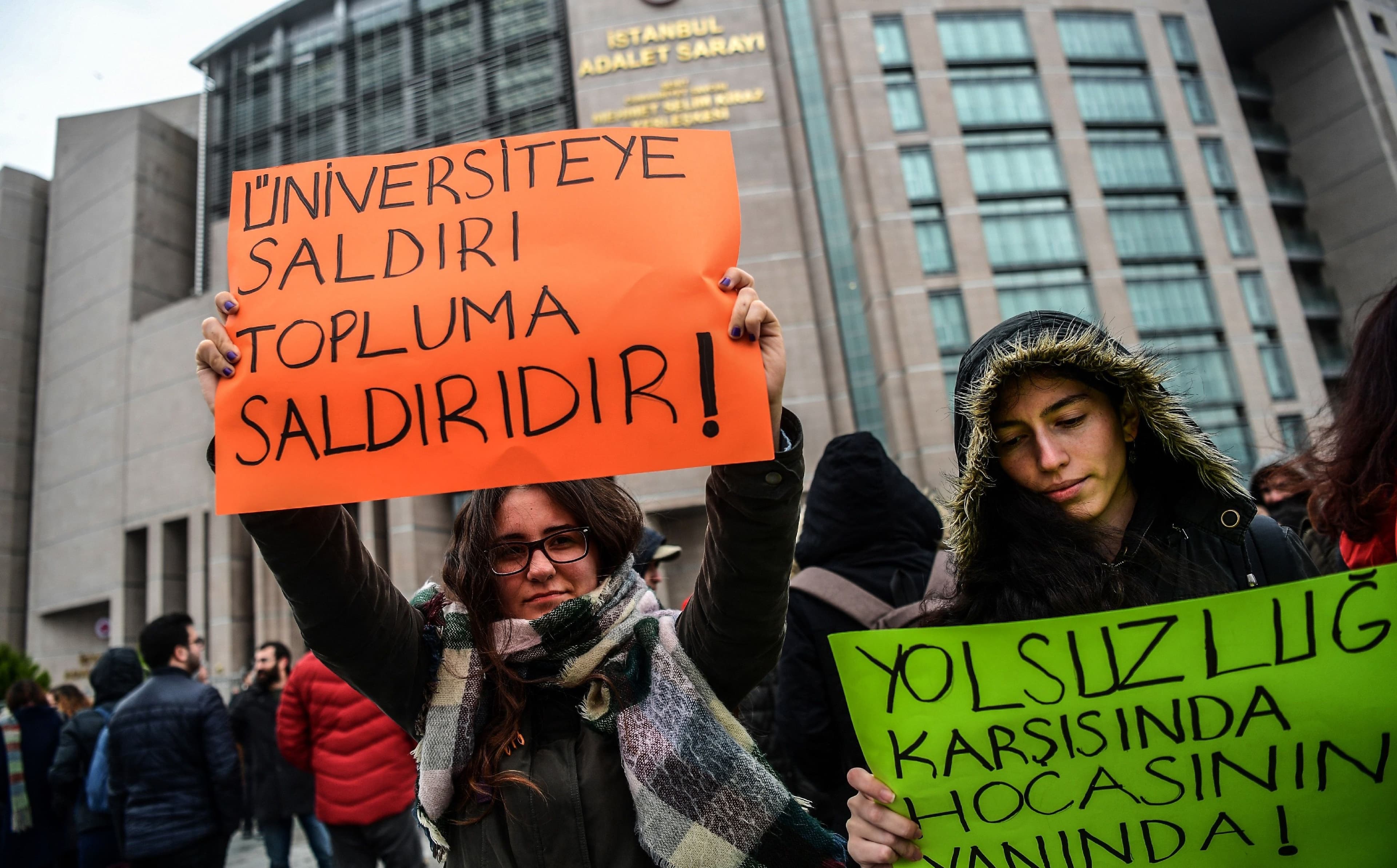 Protesters hold signs reading ‘Attack towards University is an attack towards community – Against corruption, we are with our Academics,’ during a demonstration in front of an Istanbul court in December. Photo: Ozan Kose/AFP