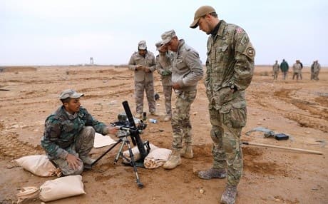 A Danish soldier observes Iraqi troops as they conduct mortar training at Camp al-Asad on February 21, 2018. Photo: Spc. Zakia Gray | US Army