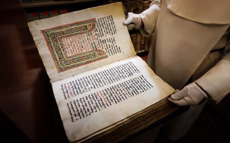 Father Najeeb Michaeel inspects an old Christian book at the Oriental Manuscript Digitisation Centre (CNDO) in Erbil, the capital of the Kurdistan Region on March 1, 2018. Photo: Safin Hamed | AFP