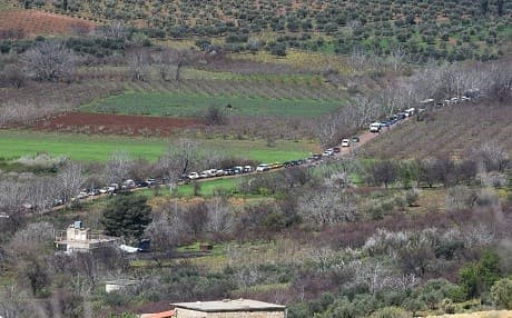 Civilians fleeing the city of Afrin drive and walk at the mountainous road of al-Ahlam while heading towards the check point in az-Ziyarah, in the regime-controlled part of the northern Aleppo province, on March 16, 2018. Photo: George Ourfalian | AFP