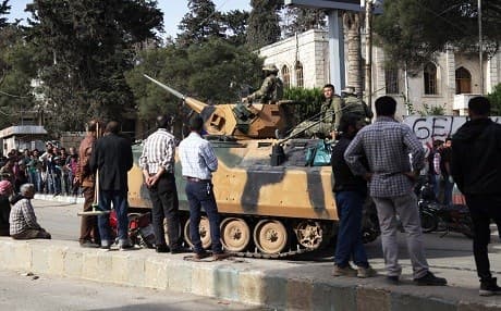 Civilians look at a Turkish military tank as they queue for food aid in Afrin city on Wednesday. Photo: Bakr Alkasem/AFP
