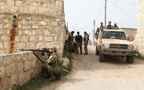 A Turkish-backed Syrian sniper takes aim as the fighters enter the village of Baay south of Afrin on March 22. Photo: Omar Haj Kadour/AFP