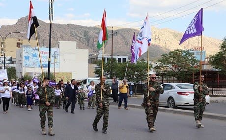 People carry the Iraq and Kurdistan's flags, as well as Assyrian ones during an Akitu parade on April 1, 2018. Photo: Vanessa Powell | Rudaw