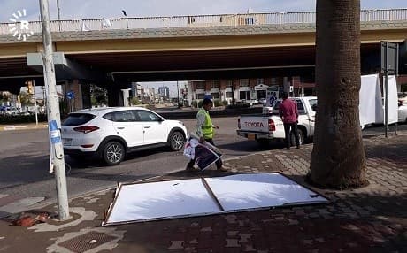 Workers clean up damaged campaign posters. Photo: Rudaw