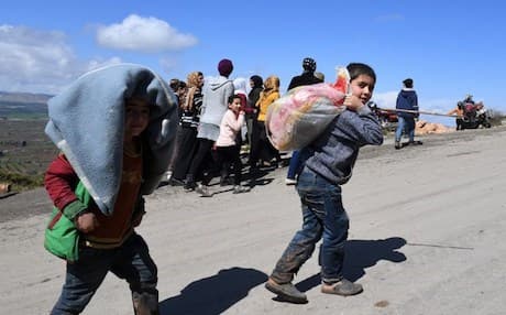 Civilians fleeing the city of Afrin in northern Syria walk at the mountainous road of al-Ahlam while heading towards the check point in az-Ziyarah, in the government-controlled part of the northern Aleppo province, on March 16, 2018. Photo: AFP/George Ourfalian.