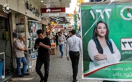 A PUK campaign poster featuring one of its female candidates hangs on a busy Sulaimani street. Photo: Sartip Othman/Rudaw