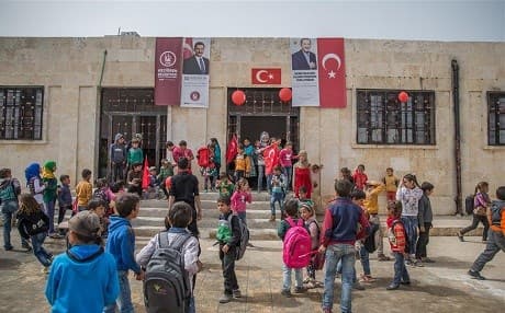 Pupils in Afrin hold Kurdish flags at al-Caviz village on March 26, 2018. Photo: AA