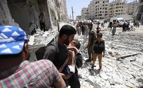 A man carries a wounded child out of a building after a car bombing in Idlib on Saturday. Photo: Omar Haj Kadour/AFP