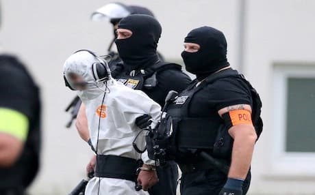 Police officers of a special unit escort Iraqi asylum seeker Ali Bashar, who is suspected of having killed a German teenage girl, to a helicopter in Wiesbaden, western Germany, on June 10, 2018, heading to a prison after Bashar testified. Photo: AFP/ Hasan Bratic