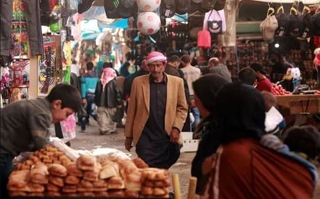 A man walks through an open air market in Manbij. Photo: Delil Souleiman/AFP